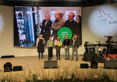 Das Bild zeigt die Vorstellung eines LEADER-Projekts beim Bühnenauftritt der LAG Ostprignitz Ruppin und der LAG Storchenland Prignitz bei der Grünen Woche. 